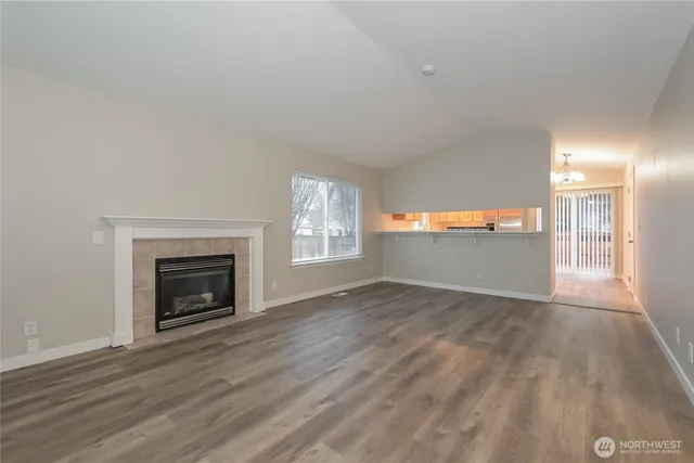a view of empty room with wooden floor and fireplace