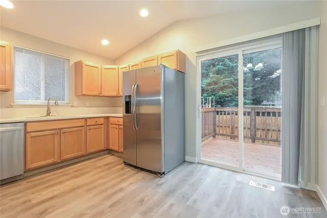 a kitchen with a refrigerator a sink and white cabinets