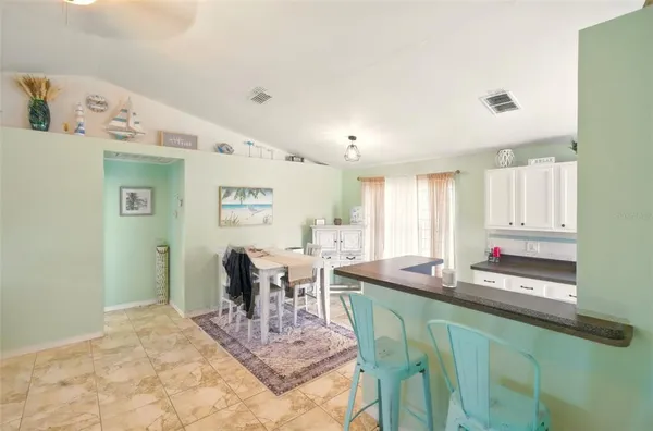 a dining hall with granite countertop a dining table and chairs in it