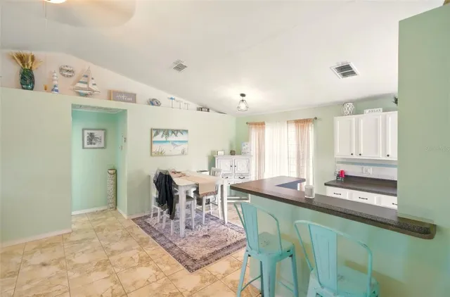 a dining hall with granite countertop a dining table and chairs in it