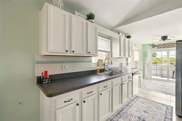 a kitchen with stainless steel appliances granite countertop a sink and a white cabinets