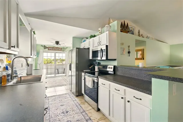 a kitchen with stainless steel appliances granite countertop a sink stove and cabinets