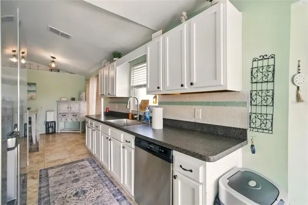 a kitchen with granite countertop a sink a stove and a wooden floors