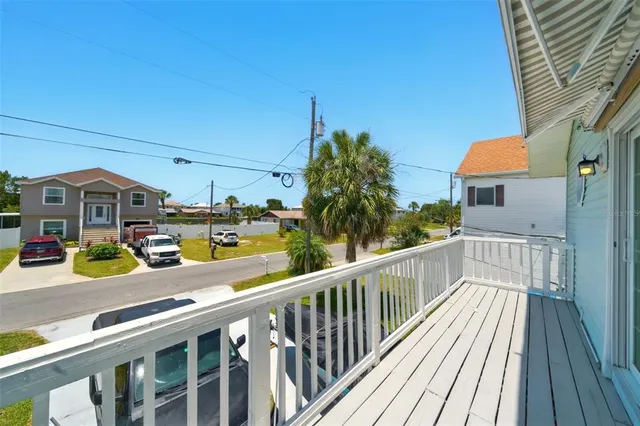 a view of a balcony with cars parked on the road
