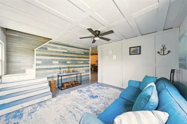 a living room with furniture and a ceiling fan