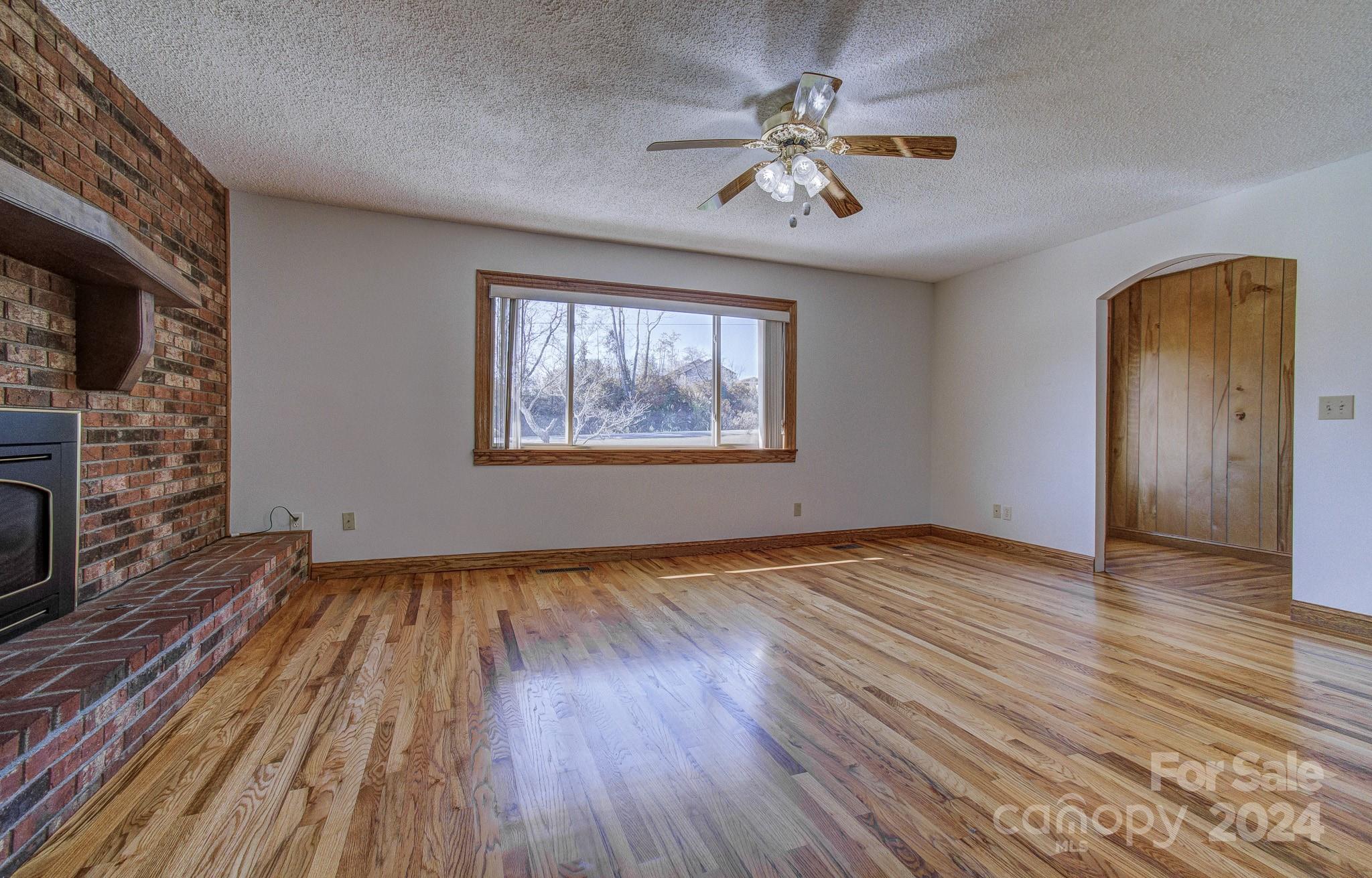 111 Souther Road Fletcher, NC 28732 - Photo 11 of 31 an empty room with wooden floor chandelier fan and windows