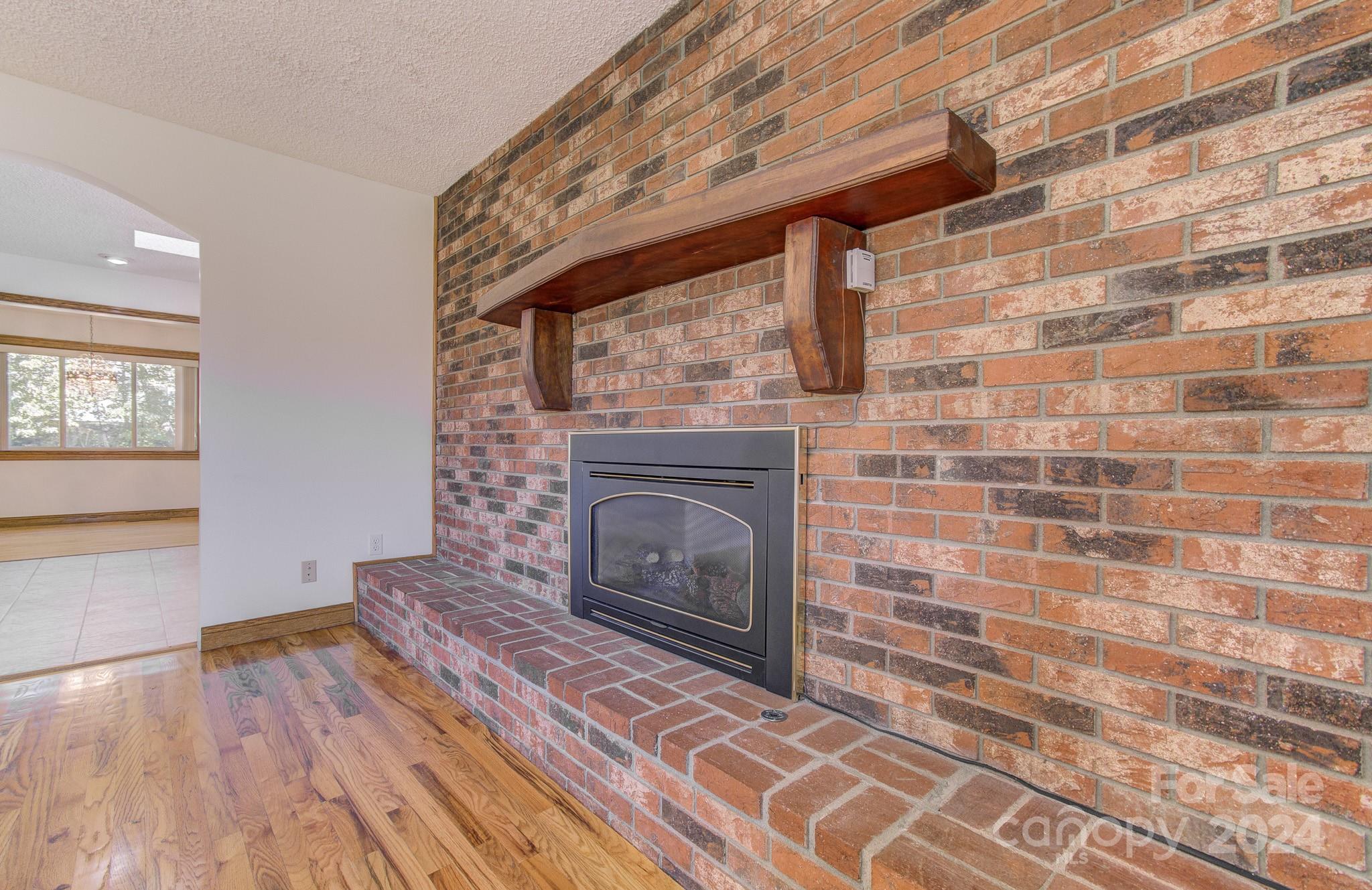 111 Souther Road Fletcher, NC 28732 - Photo 12 of 31 a living room with a fireplace and a wooden floor