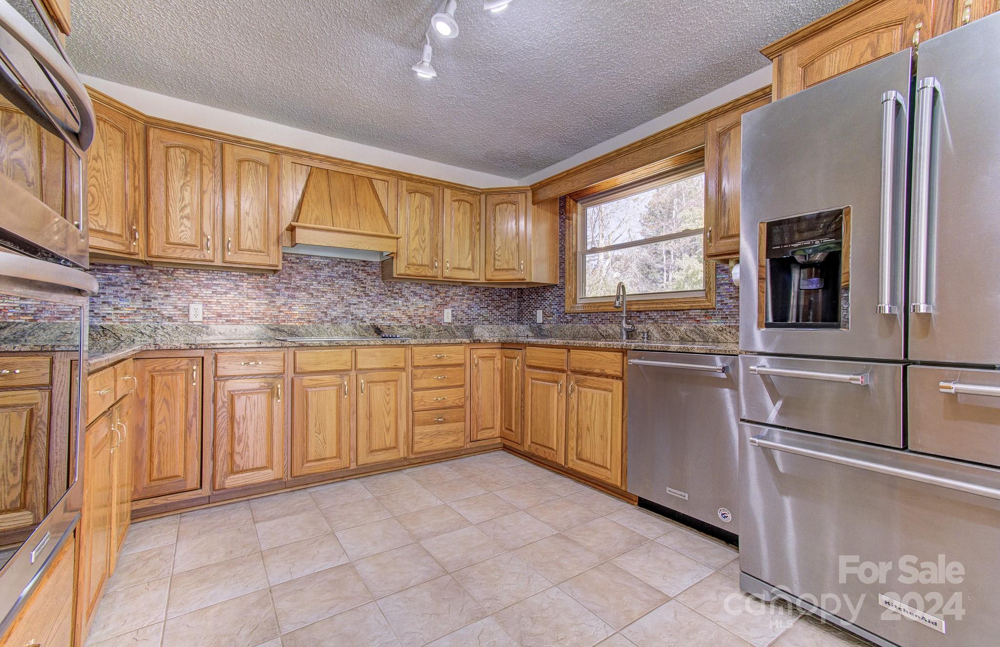 111 Souther Road Fletcher, NC 28732 - Photo 3 of 31 a kitchen with granite countertop a sink stainless steel appliances and cabinets