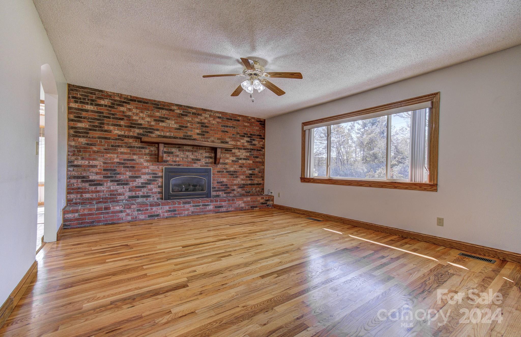 111 Souther Road Fletcher, NC 28732 - Photo 4 of 31 wooden floor fireplace and windows in an empty room