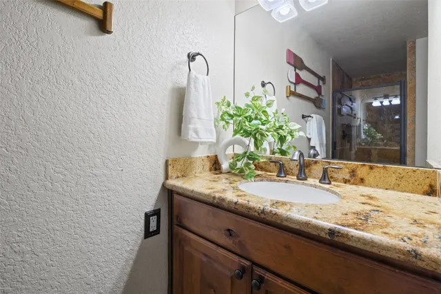 a bathroom with a granite countertop sink and a mirror