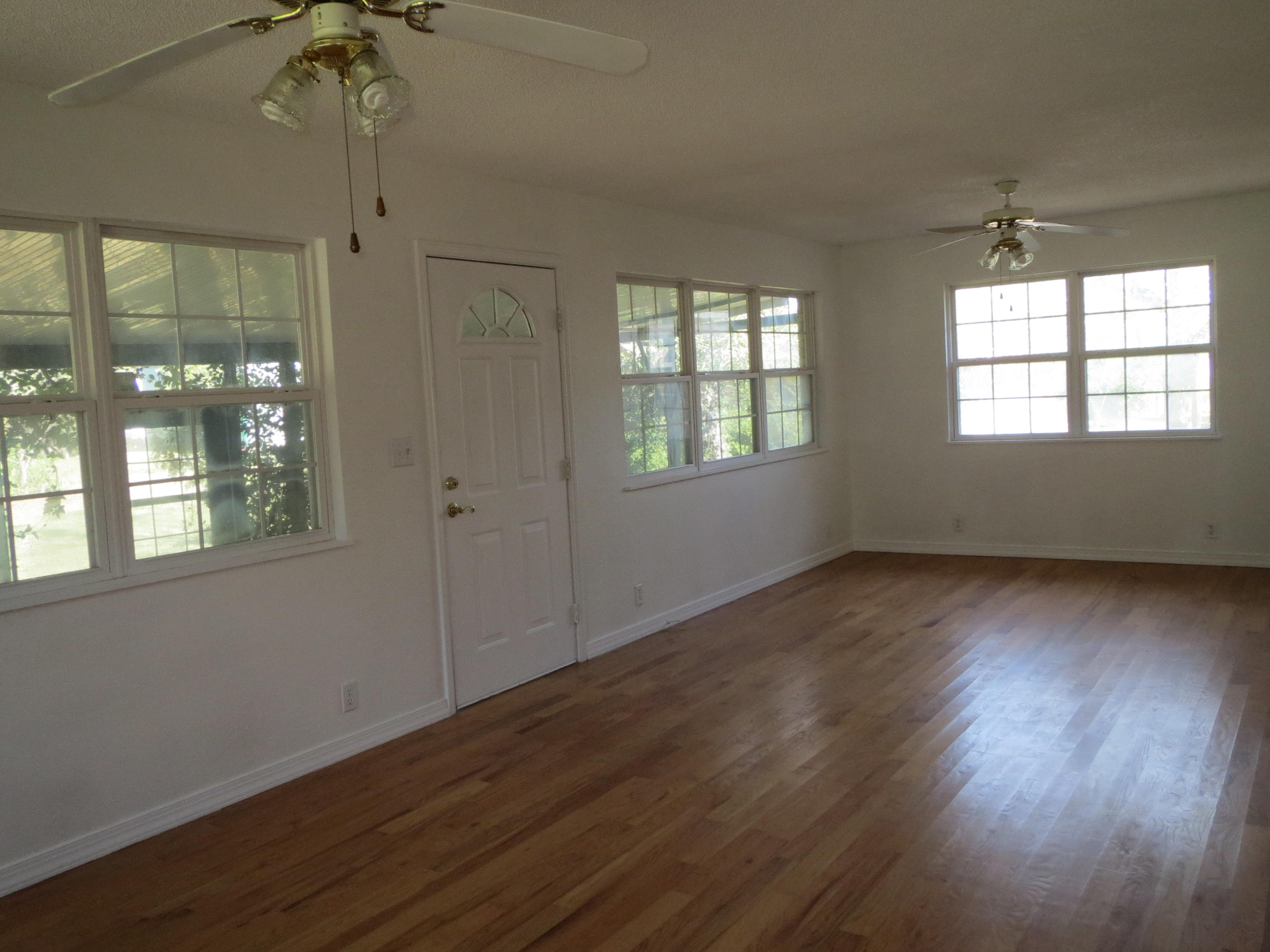 932 Tri County Road Graceville, FL 32440 - Photo 15 of 40 a view of an empty room with wooden floor and a window
