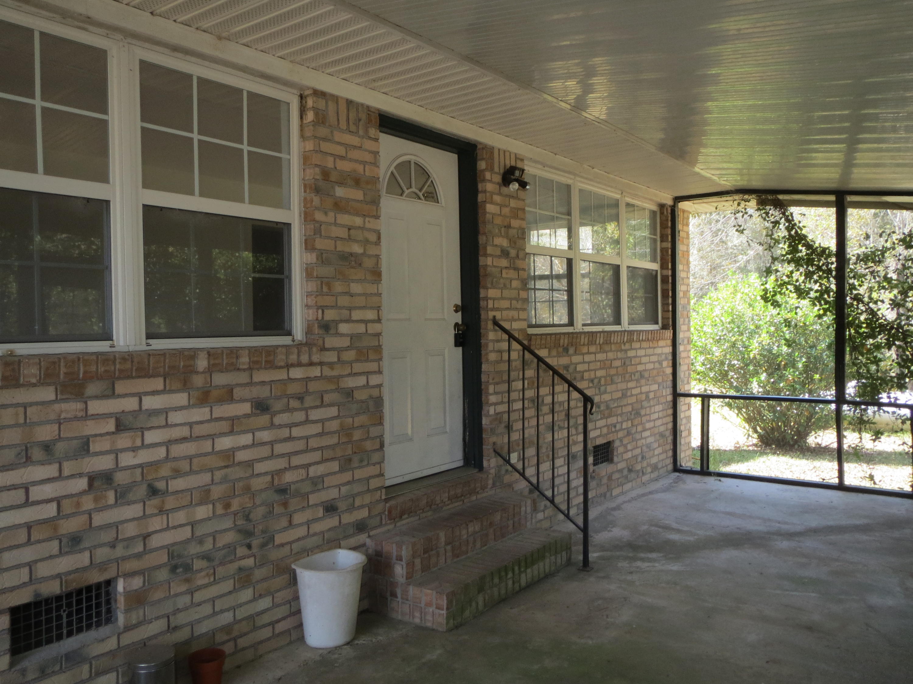 932 Tri County Road Graceville, FL 32440 - Photo 19 of 40 a view of a porch with wooden floor and a gate