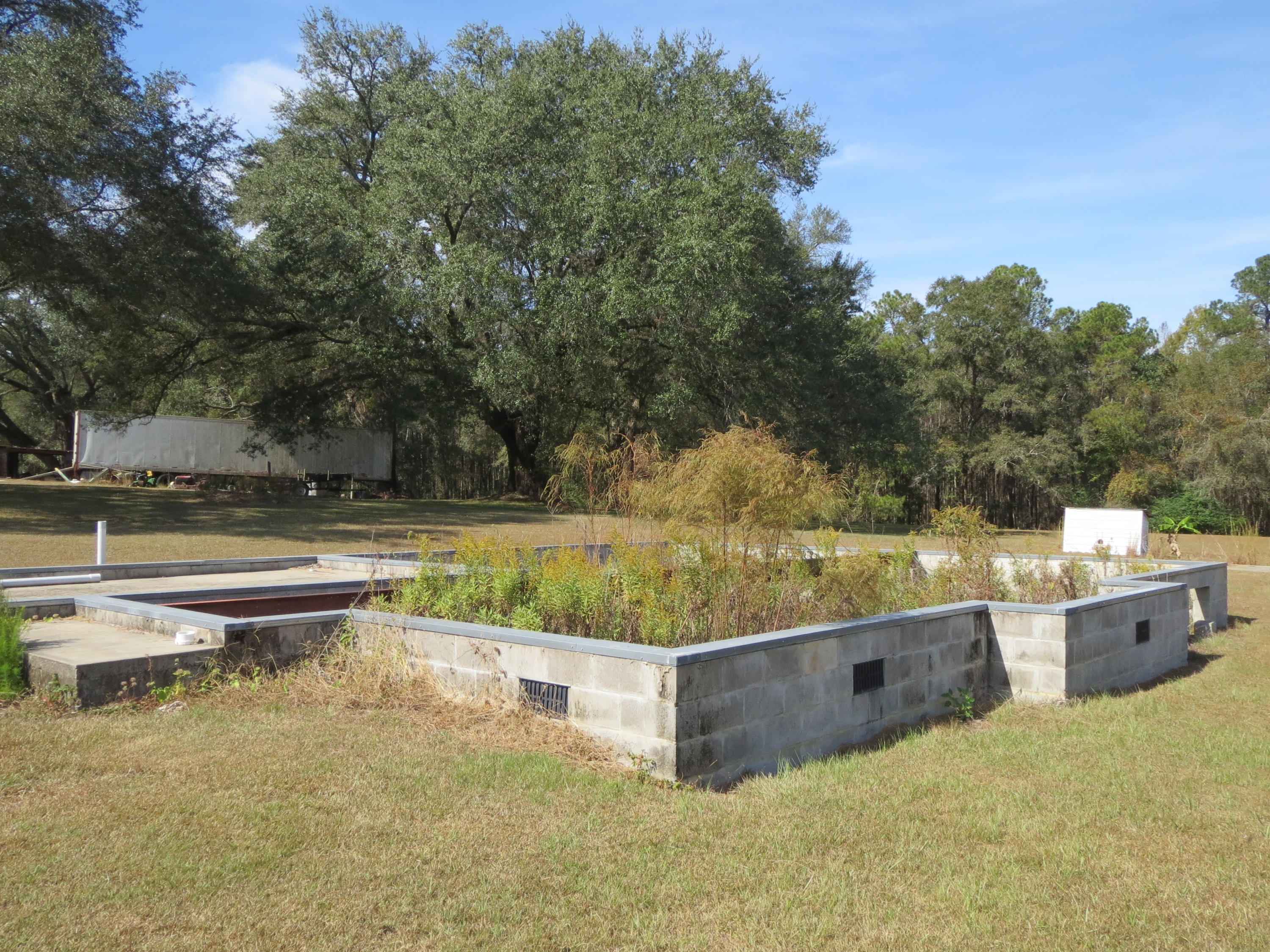 932 Tri County Road Graceville, FL 32440 - Photo 28 of 40 a view of a swimming pool with a yard and sitting area