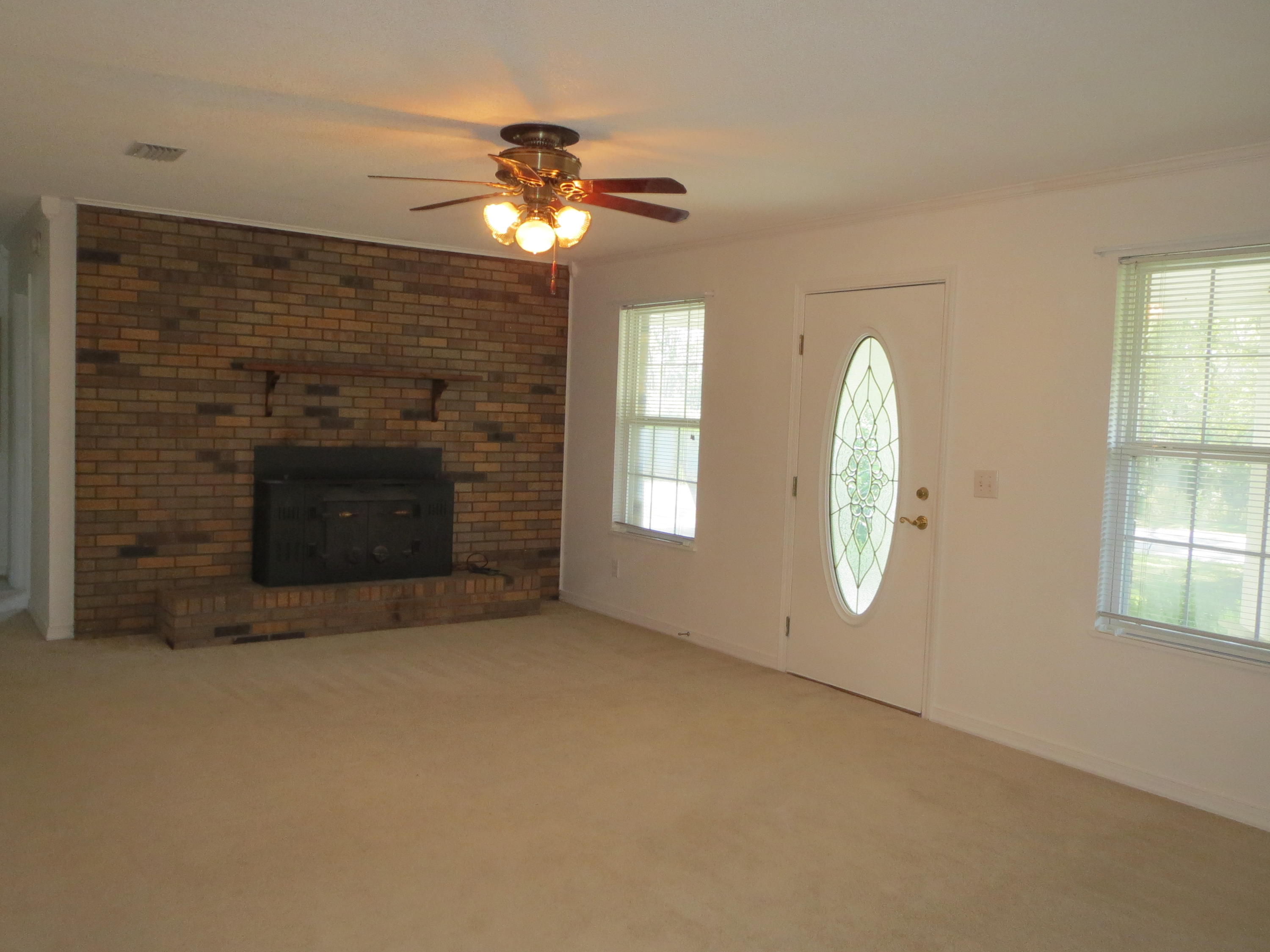 932 Tri County Road Graceville, FL 32440 - Photo 7 of 40 an empty room with chandelier fan and windows