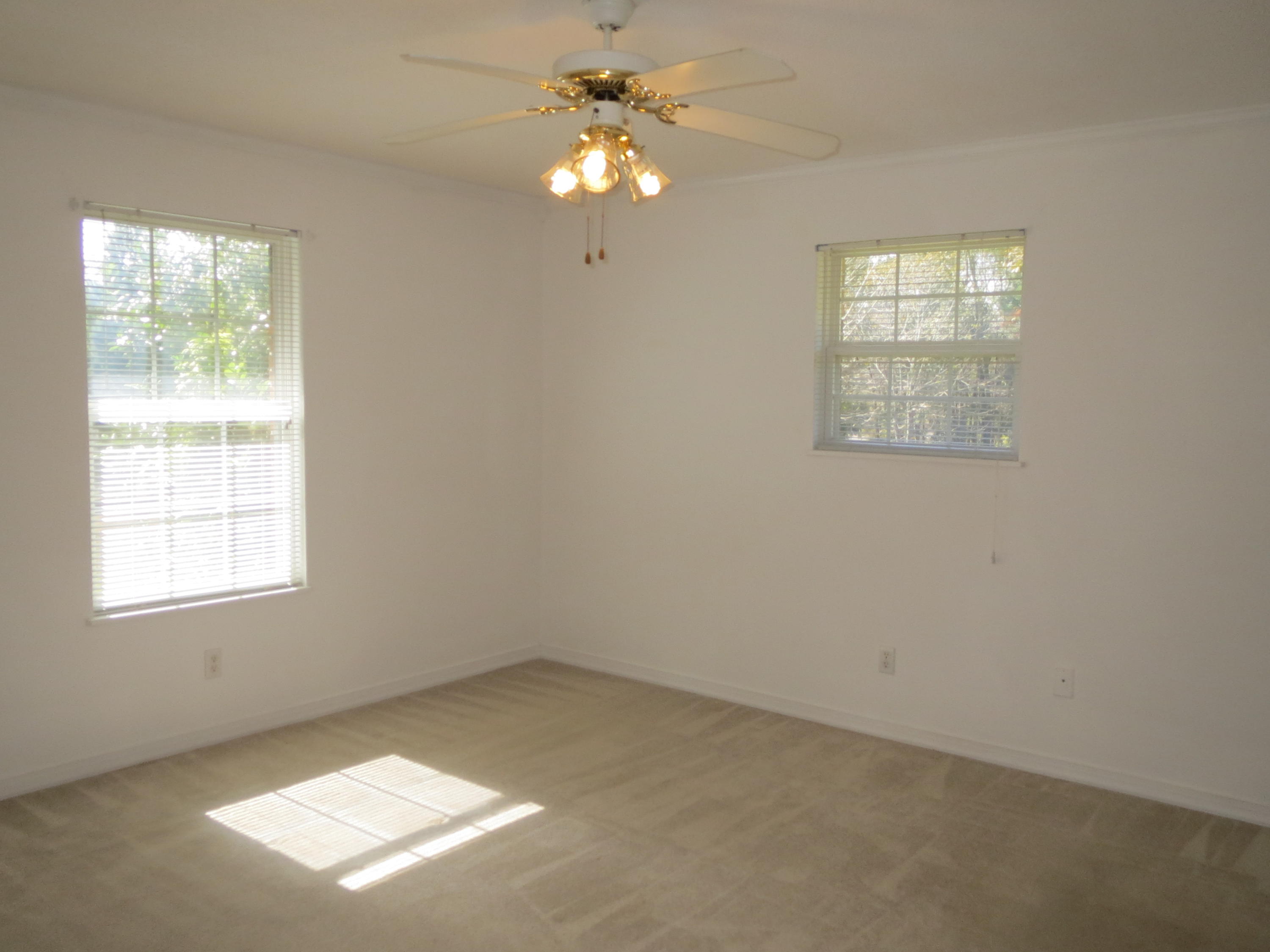 932 Tri County Road Graceville, FL 32440 - Photo 8 of 40 an empty room with windows and fan