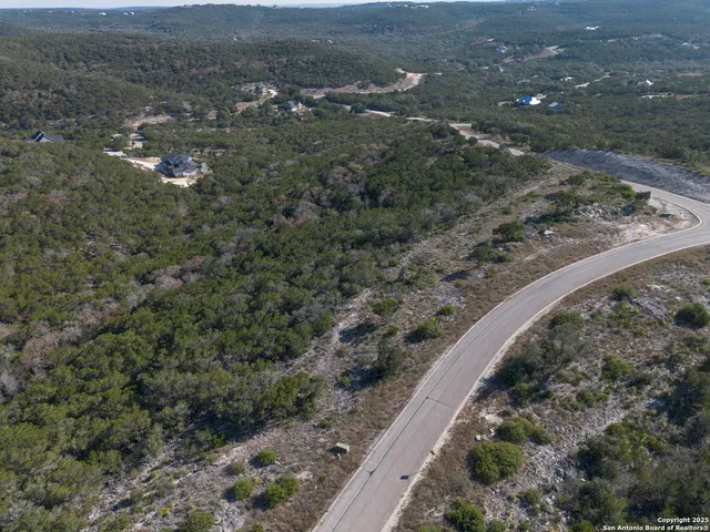 an aerial view of house with yard and mountain view in back