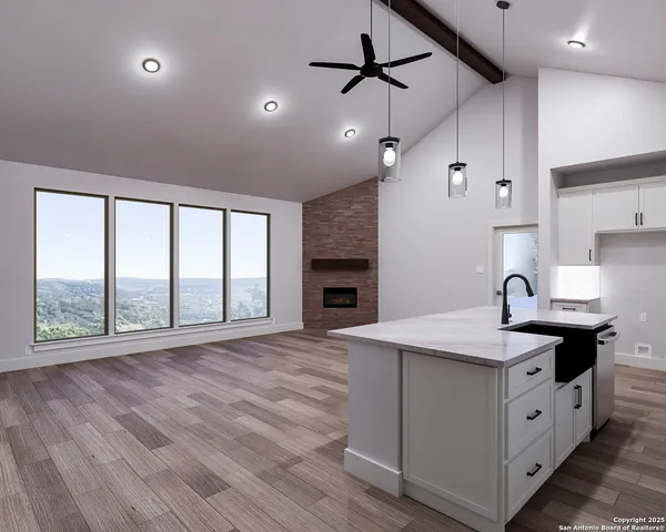 a kitchen with stainless steel appliances granite countertop a sink a stove and a wooden floors