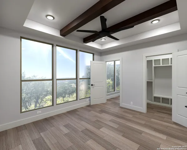 a view of an empty room with a window and wooden floor