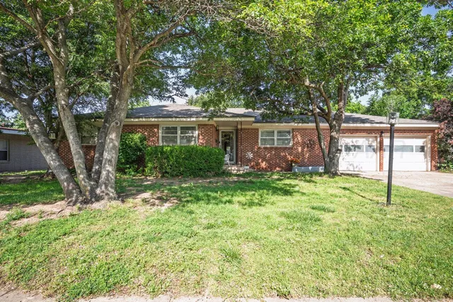 a view of a house with backyard and a tree