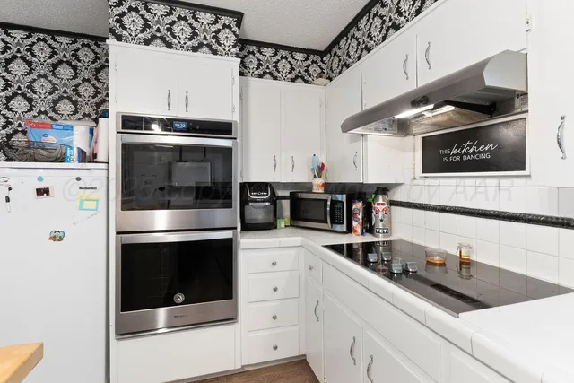 a kitchen with stainless steel appliances a sink stove and microwave