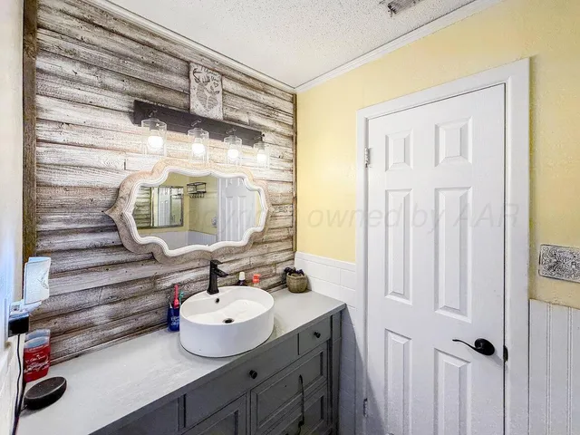 a bathroom with a sink mirror and vanity