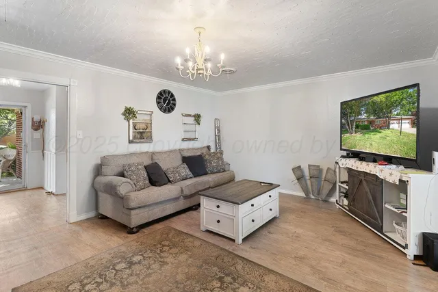 a living room with furniture and a chandelier