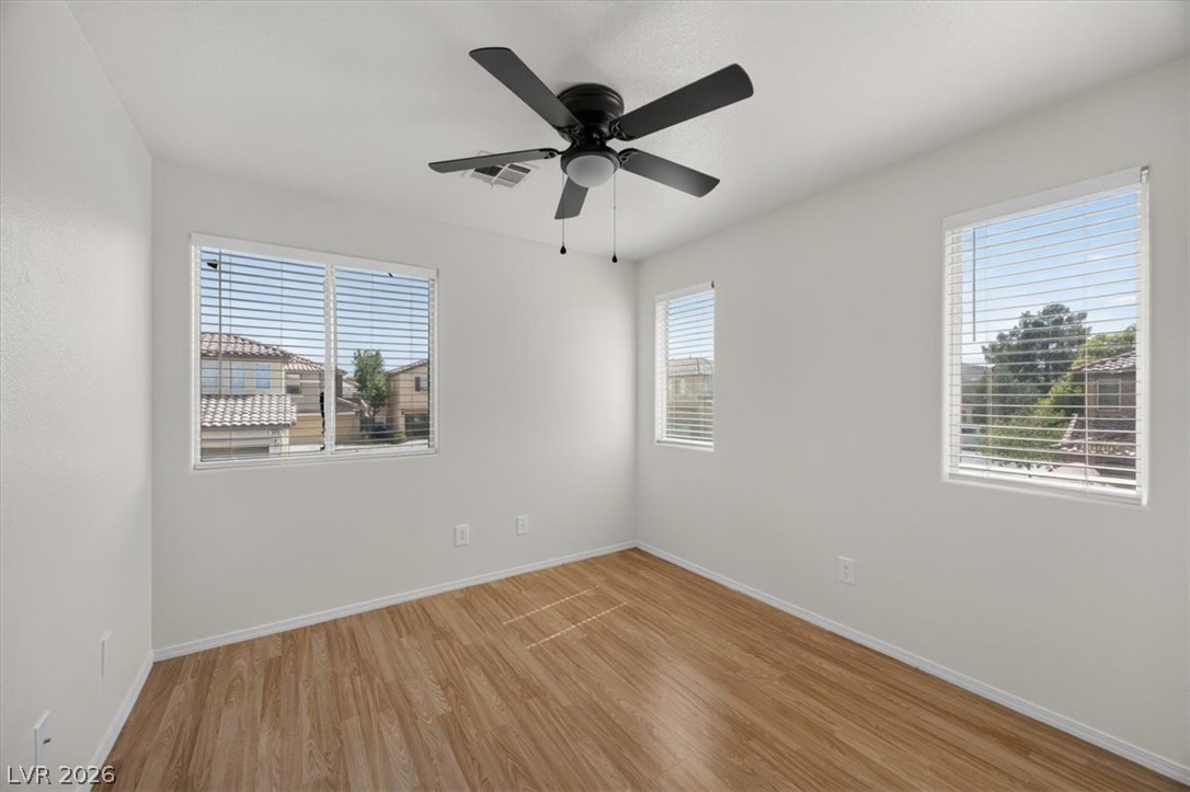 552 Albacate Street Henderson, NV 89015 - Photo 28 of 40 Well-lit room featuring durable laminate flooring and a cooling ceiling fan.