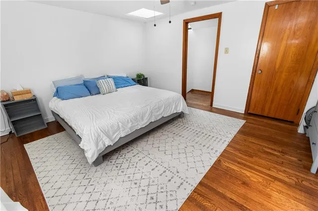 a bedroom with a bed rug and wooden floor