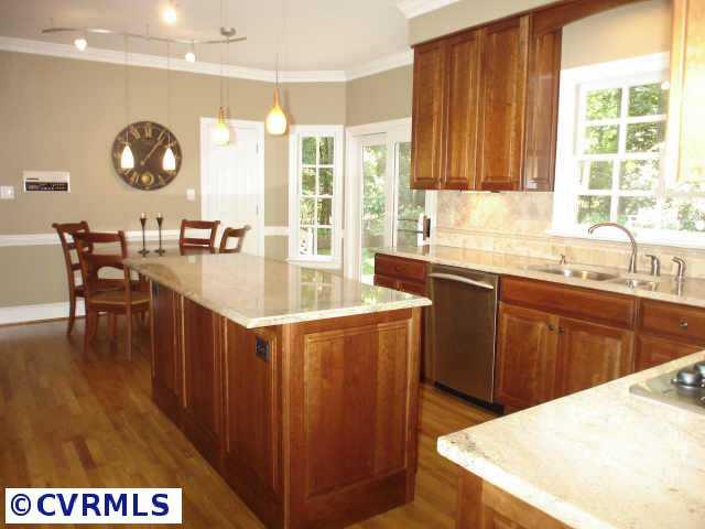 12005 Reeds Bluff Lane Midlothian, VA 23113 - Photo 8 of 10 a kitchen with a stove a sink a dining table and chairs