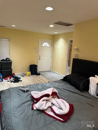 a bedroom with a bed and a dresser with wooden floor