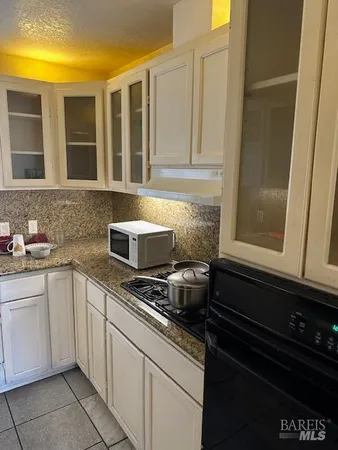 a kitchen with granite countertop cabinets a sink and a stove
