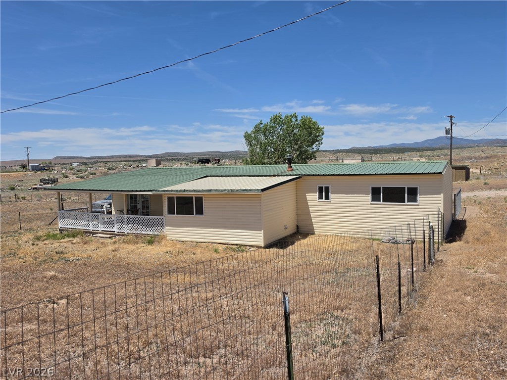 2930 Frehner Ranch Road Pioche, NV 89043 - Photo 12 of 39 A quaint residence featuring a covered porch, set against a distant mountain backdrop.