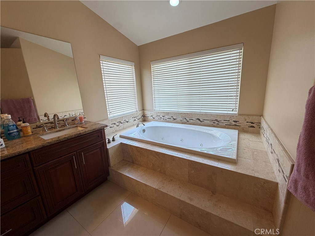 19823 Mariposa Pines Way Porter Ranch, CA 91326 - Photo 28 of 50 a bathroom with a granite countertop sink and a bathtub