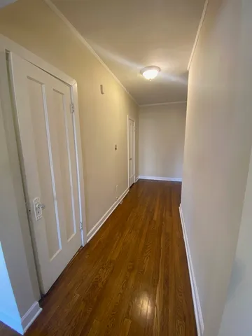 a view of a hallway with wooden floor