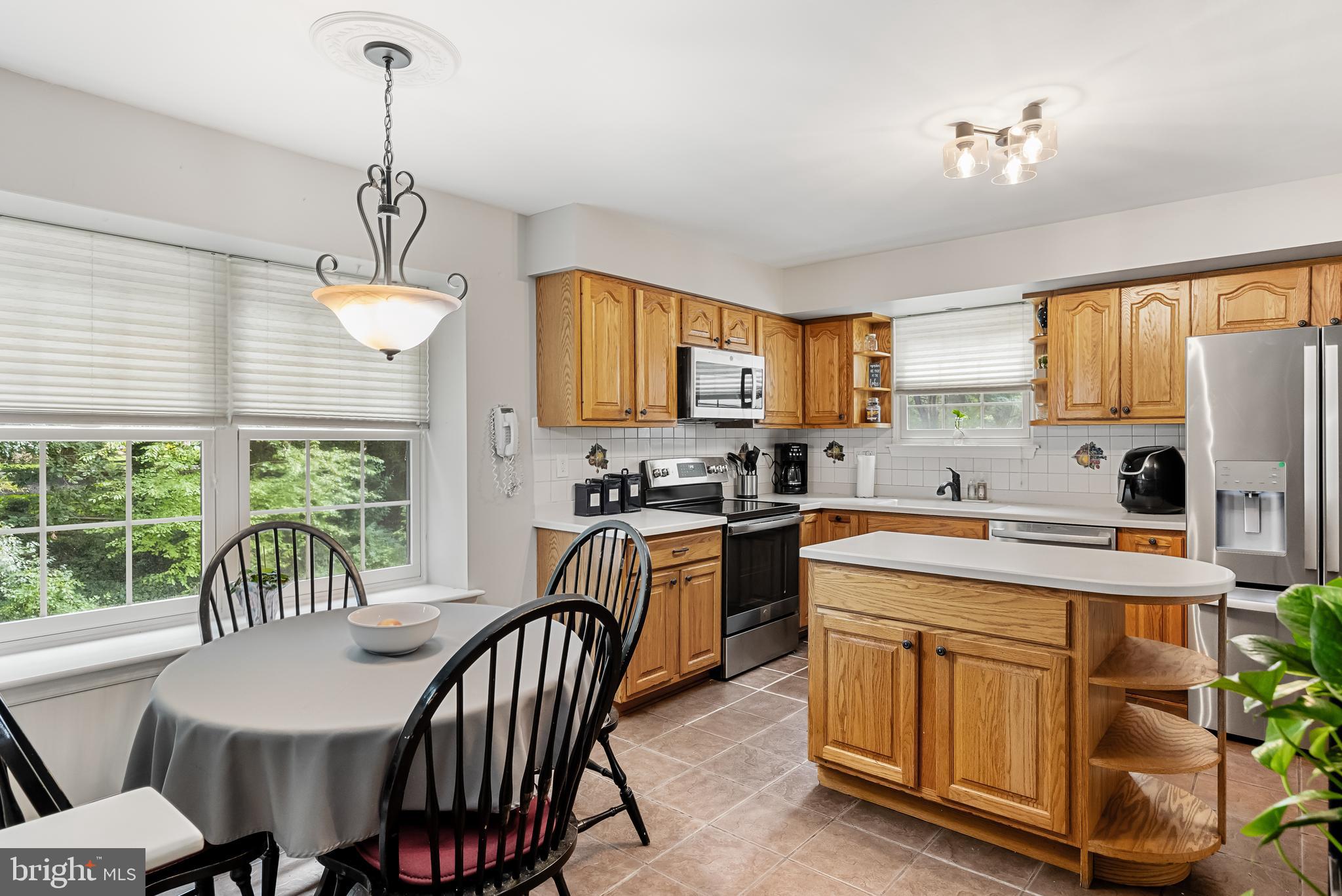 26 Brookview Drive Voorhees, NJ 08043 - Photo 16 of 50 a kitchen with a table chairs stove and cabinets