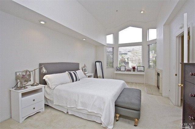 a bedroom with a bed and large window