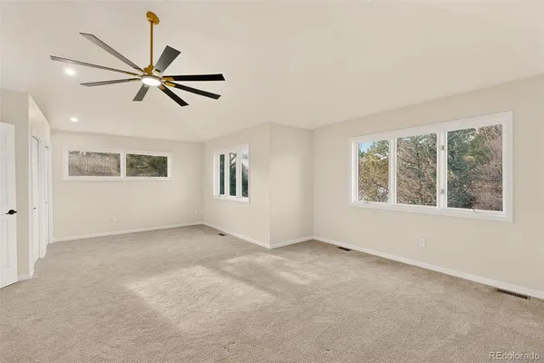 an empty room with ceiling fan and window