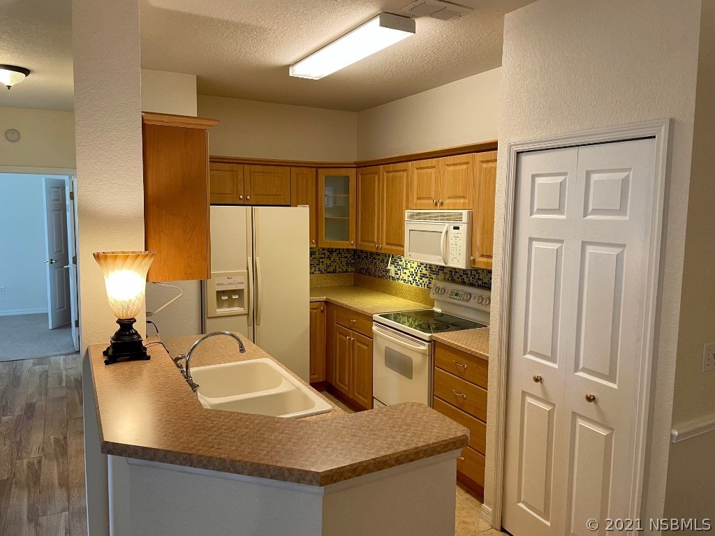 830 Airport Road, Unit 202 Port Orange, FL 32128 - Photo 14 of 35 a kitchen with stainless steel appliances granite countertop a sink a stove and a refrigerator