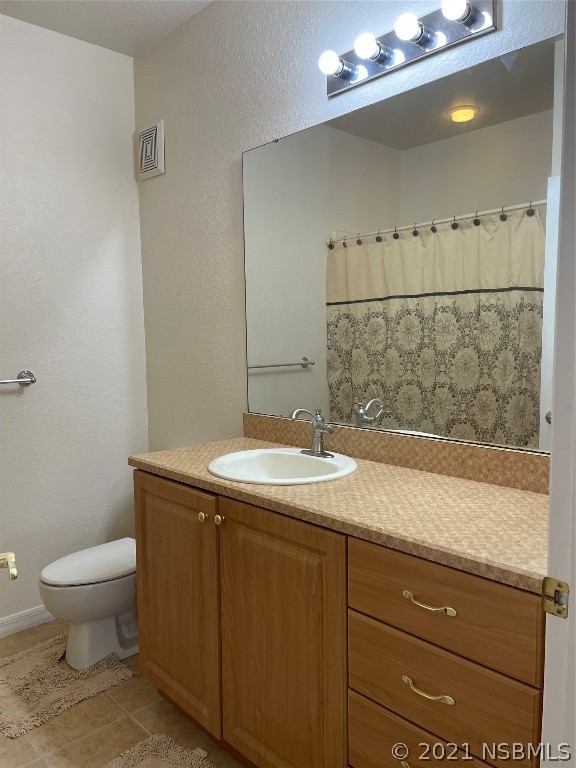 830 Airport Road, Unit 202 Port Orange, FL 32128 - Photo 29 of 35 a bathroom with a granite countertop sink a toilet and mirror