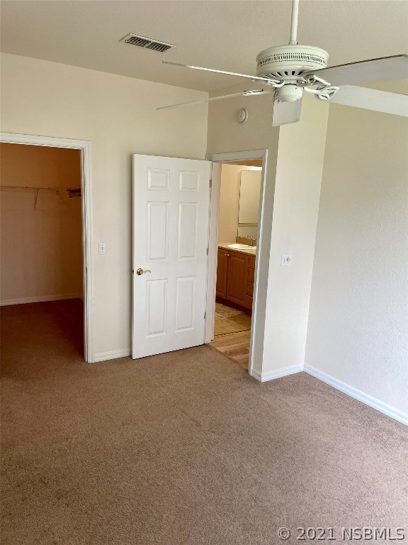 830 Airport Road, Unit 202 Port Orange, FL 32128 - Photo 31 of 35 en empty room with chandelier fan and kitchen view