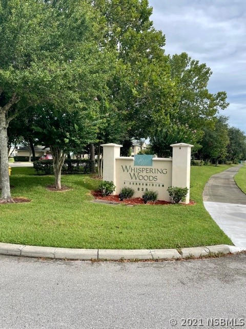 830 Airport Road, Unit 202 Port Orange, FL 32128 - Photo 4 of 35 a view of a white house with a small yard and large trees