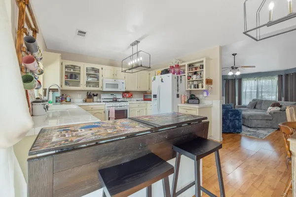 a bedroom with a bed and dresser with wooden floor