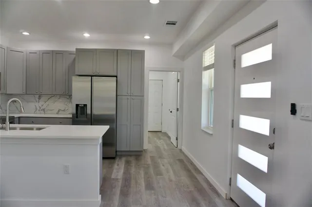 a kitchen with stainless steel appliances granite countertop a refrigerator and a sink