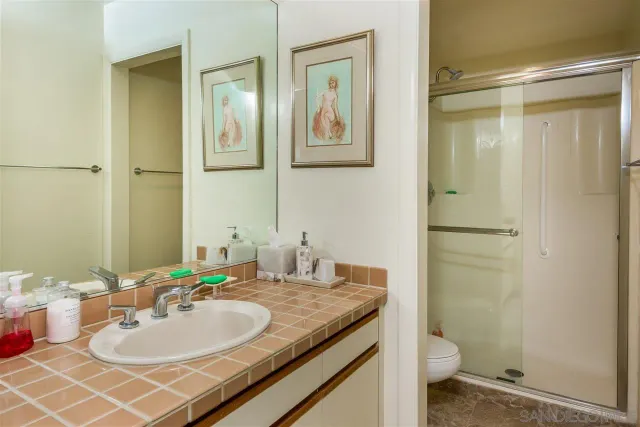 a bathroom with a granite countertop sink toilet and shower