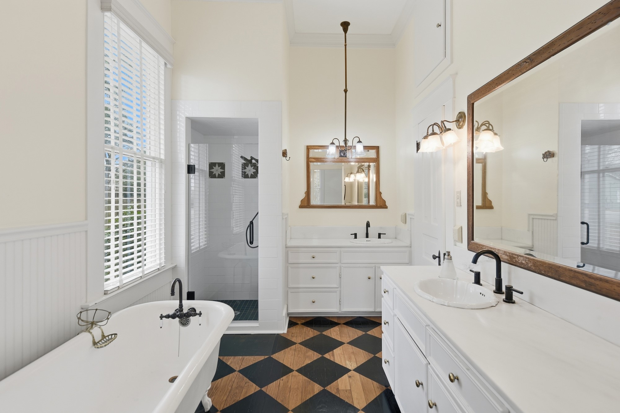 1406 Key Street Brenham, TX 77833 - Photo 19 of 50 Experience luxury in the primary en-suite with stunning antique hardwood floors, elegant double vanities, and a relaxing soaking tub.