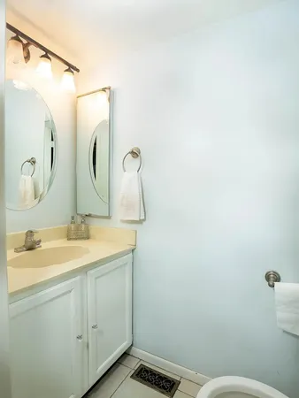 a bathroom with a granite countertop sink a mirror and a toilet