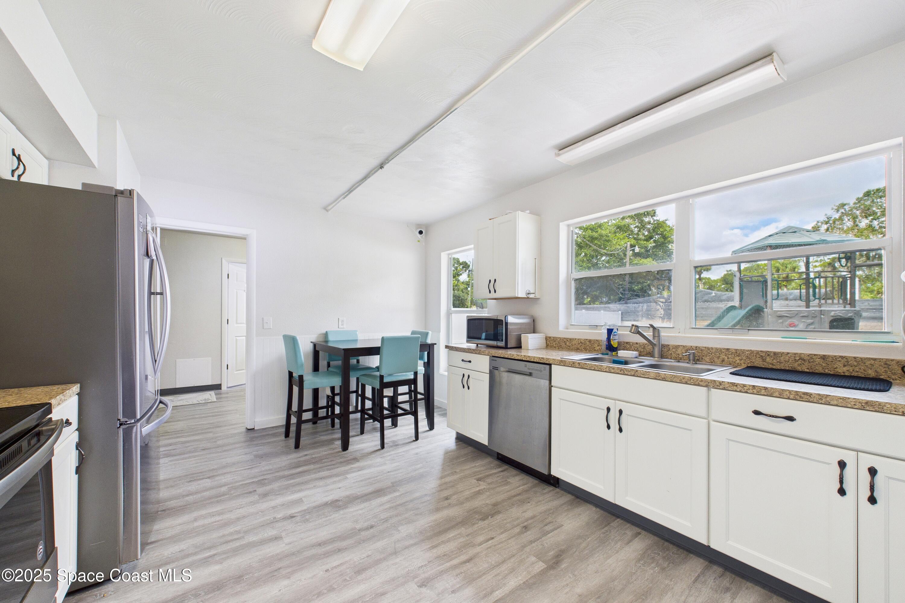 1340 South Wickham Road Melbourne, FL 32904 - Photo 17 of 50 a kitchen with appliances a sink a counter top space and a center island