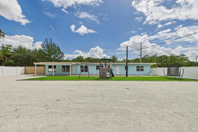 a view of a house with a backyard and a garage