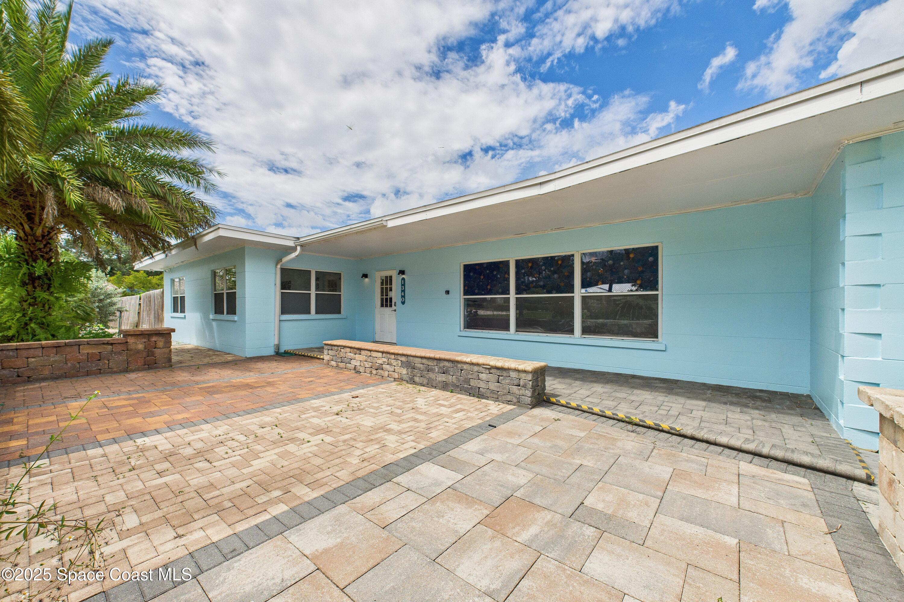 1340 South Wickham Road Melbourne, FL 32904 - Photo 30 of 50 a view of a house with a backyard and a garage