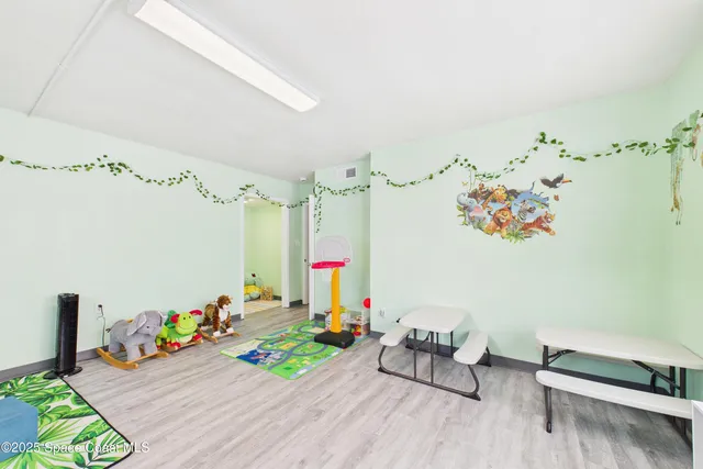 a sidewalk with a building and trees in the background